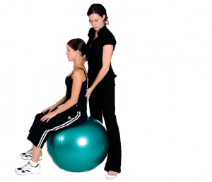 Physio correcting a client sitting on a fitball 